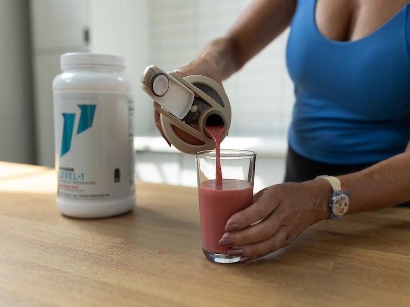 A tester pours 1st Phorm Level-1 Protein Powder into a glass