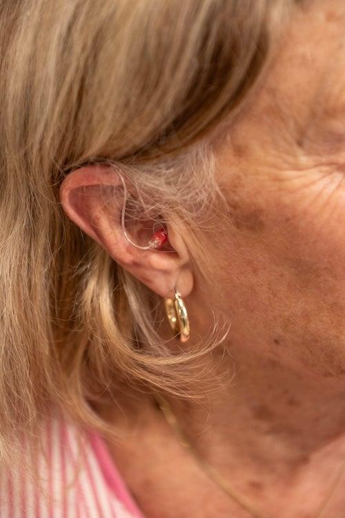 A woman wearing the Ceretone Beacon RIC hearing aids