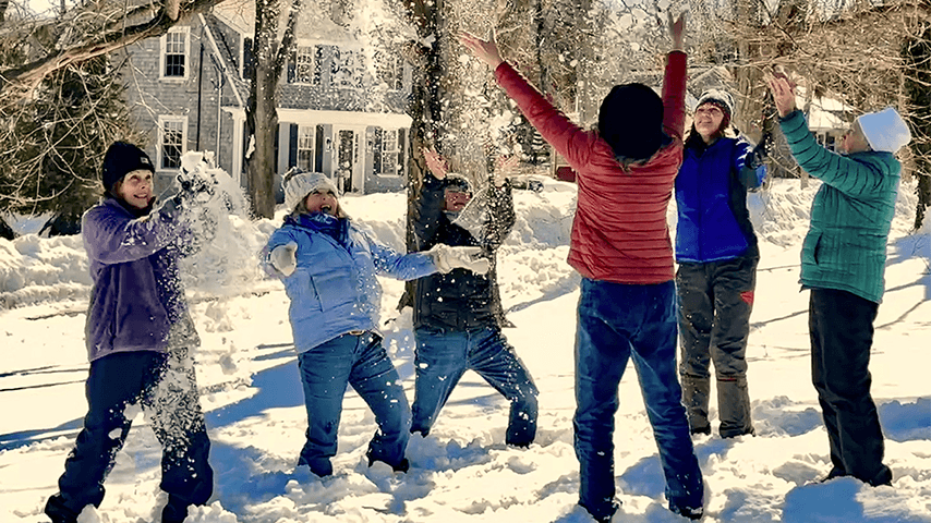 group of multigenerational women playing in the snow