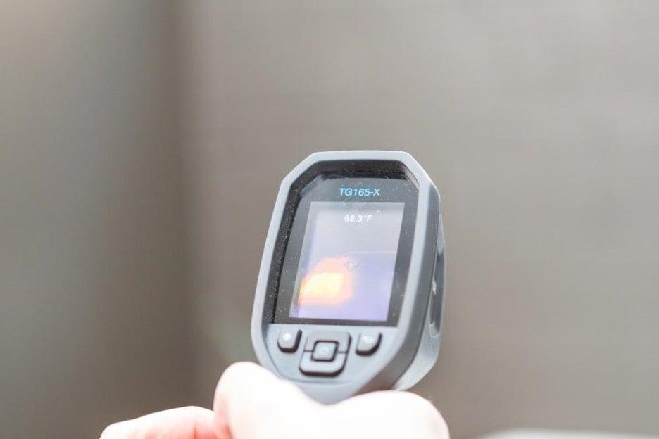 A heat gun shows a temperature readout for the Bear Original mattress