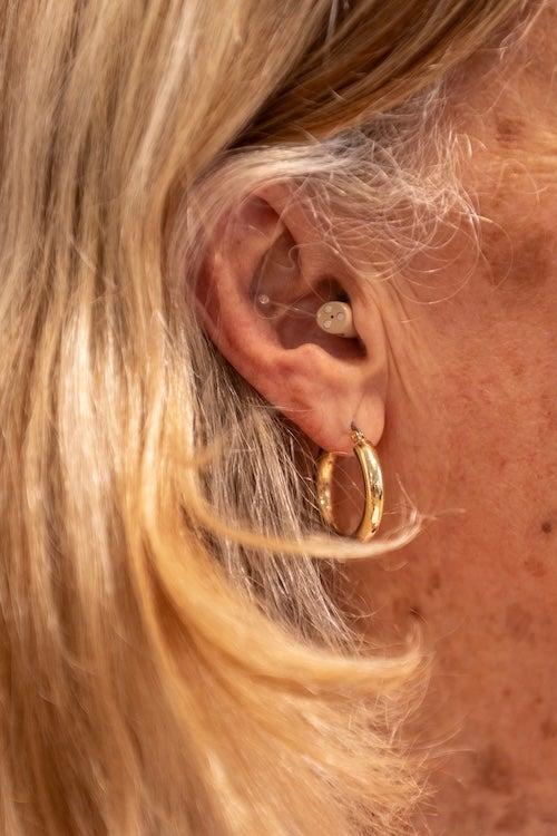 A woman wearing the Ceretone Core One Pro hearing aids