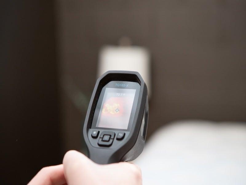 A thermal gun is pointed at the Helix Midnight Luxe mattress