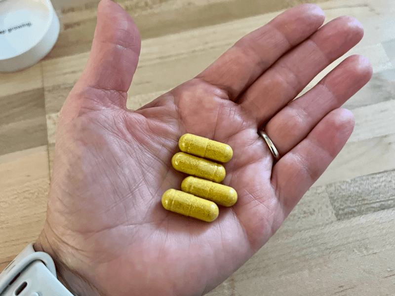 Nutrafol tester holding the daily dose of Nutrafol—four capsules—in their palm