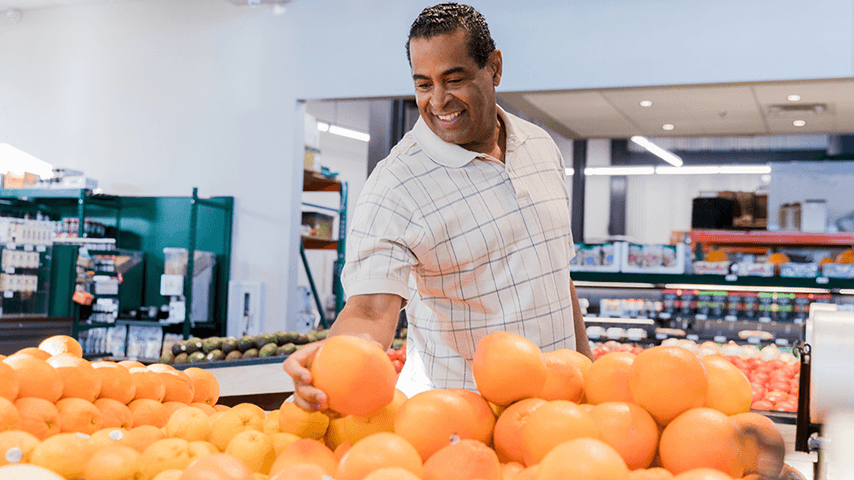 man picking out grapefruit in grocery store