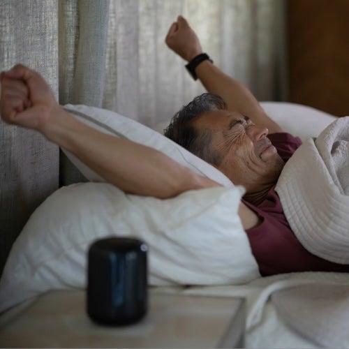 A man waking up and stretching in bed