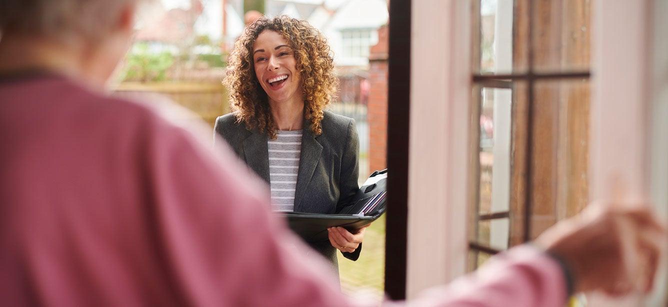 A senior center professional is at a client's door for their regular visit.