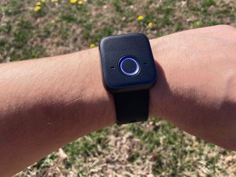 The MGMini Lite on a person's wrist with grass in the background