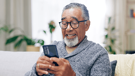 smiling older man looking at smartphone screen