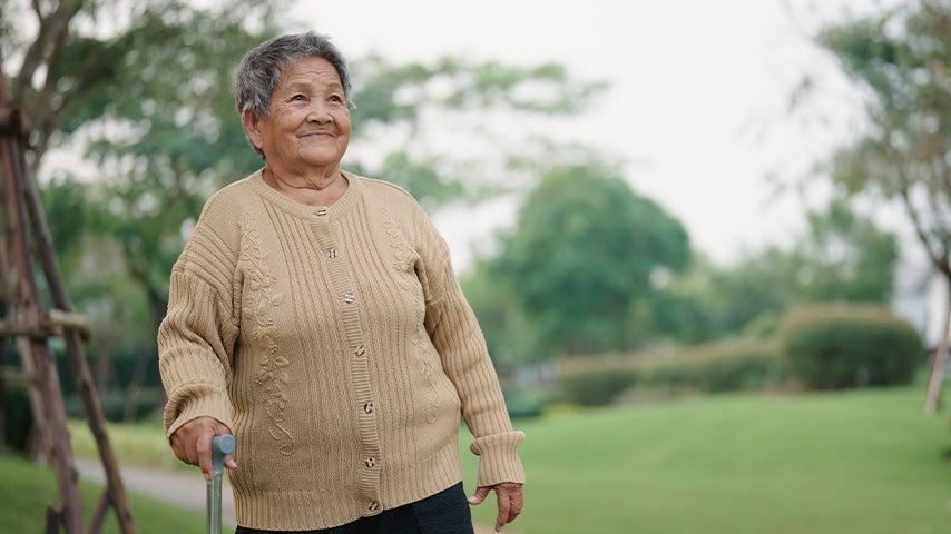 An adult woman walking with a cane