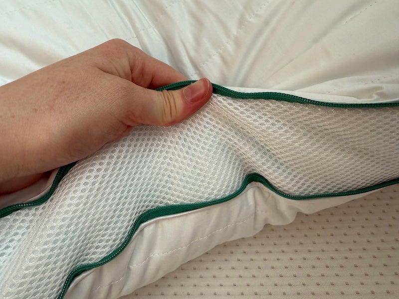 A hand holds the mesh side of the Brooklinen Marlow pillow.
