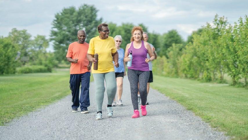 A group of adults jogs on a path.