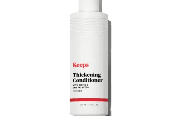 A bottle of Keeps Thickening Conditioner against a white background