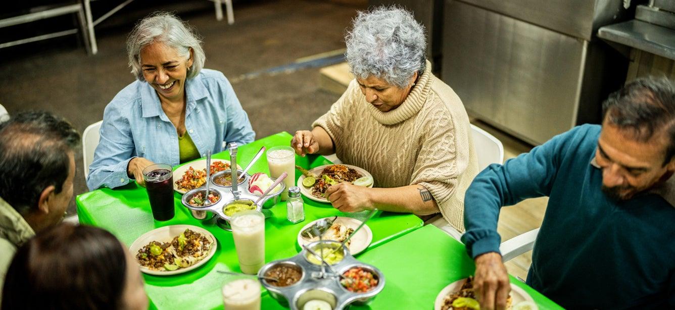 A group of older adults sitting at a table and eating.
