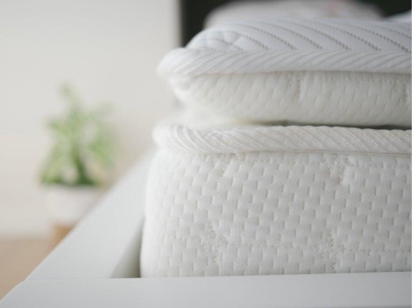 Soft white mattress on a white bed frame