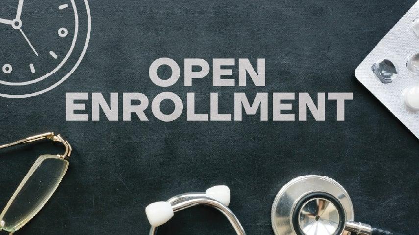 Open enrollment headline on a chalkboard with medical items in the background.