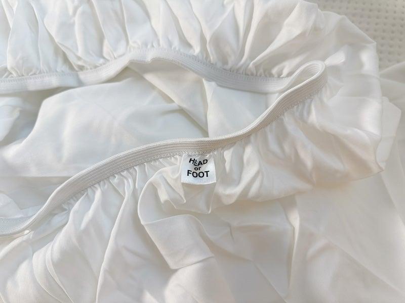 The Nectar Serenity Bamboo sheet set close up with a tag showing which side is the head or foot of the sheet