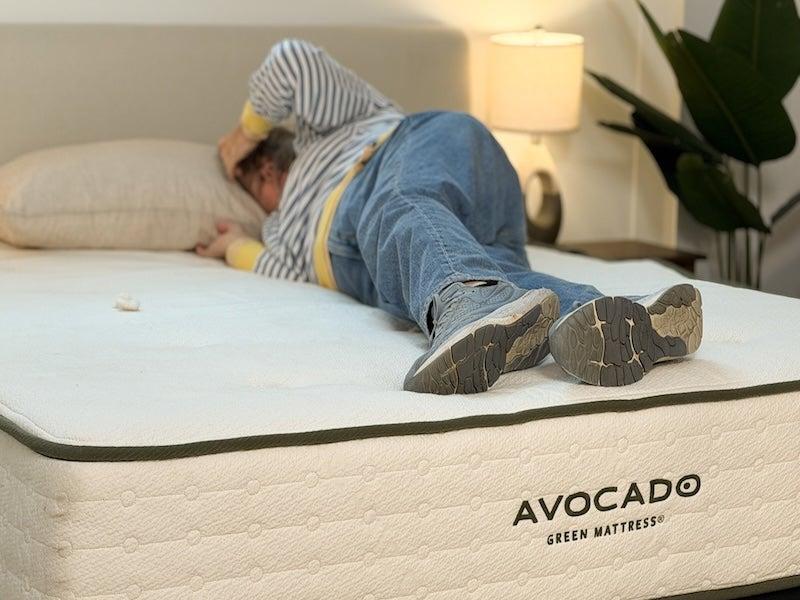 A woman rolls over on the Avocado Green mattress