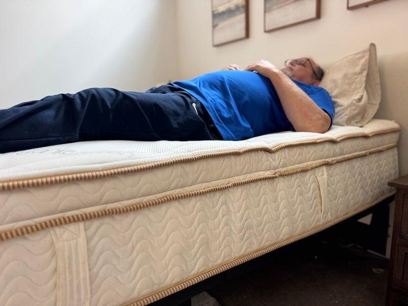 A man lies on his back on the Saatva Latex mattress