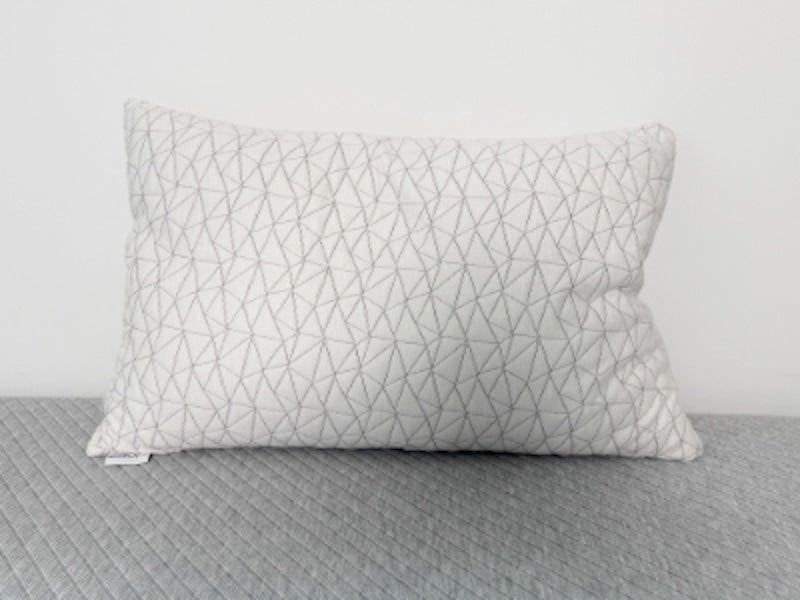 The grey Coop Sleep Goods Adjustable Pillow propped up against a wall