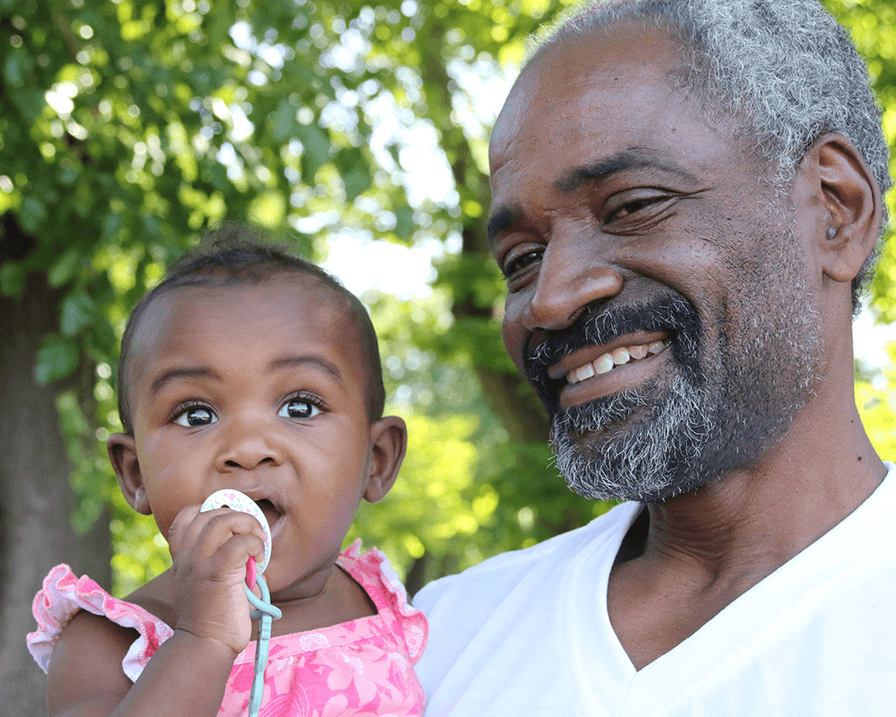 proud grandfather holding baby grandaughter
