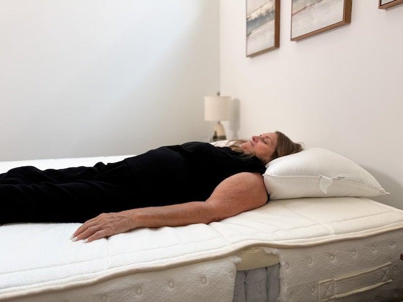 A woman lies on her back on the Awara Essential Hybrid Mattress