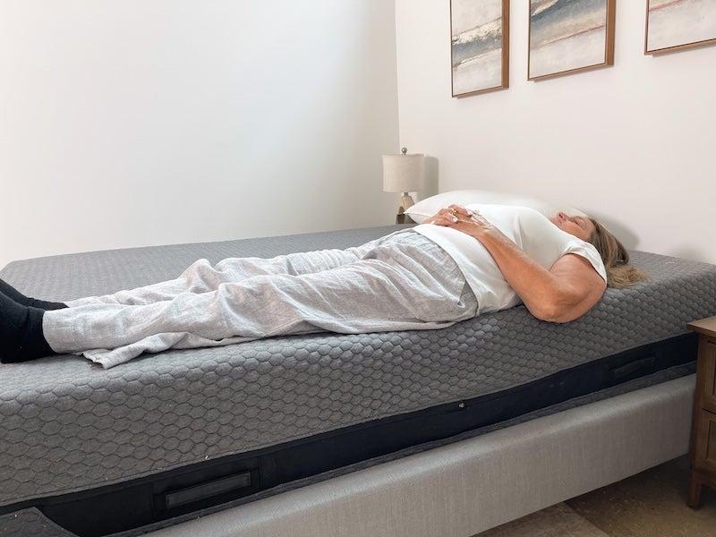 A woman lying on her back near the edge of the Layla Classic Hybrid Mattress