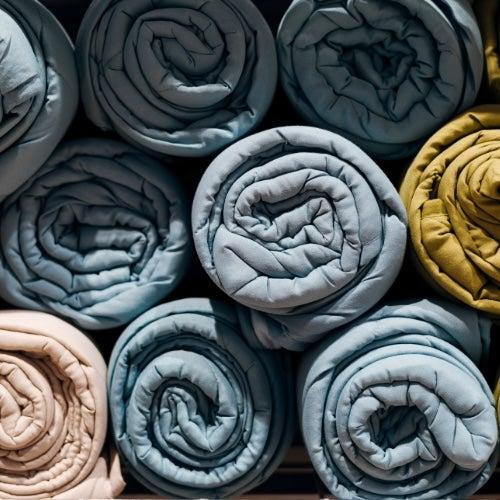 A pile of multicolored rolls of weighted blankets