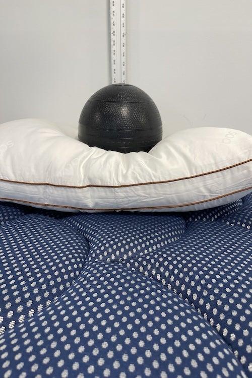 A weighted ball sitting on the Saatva Latex pillow