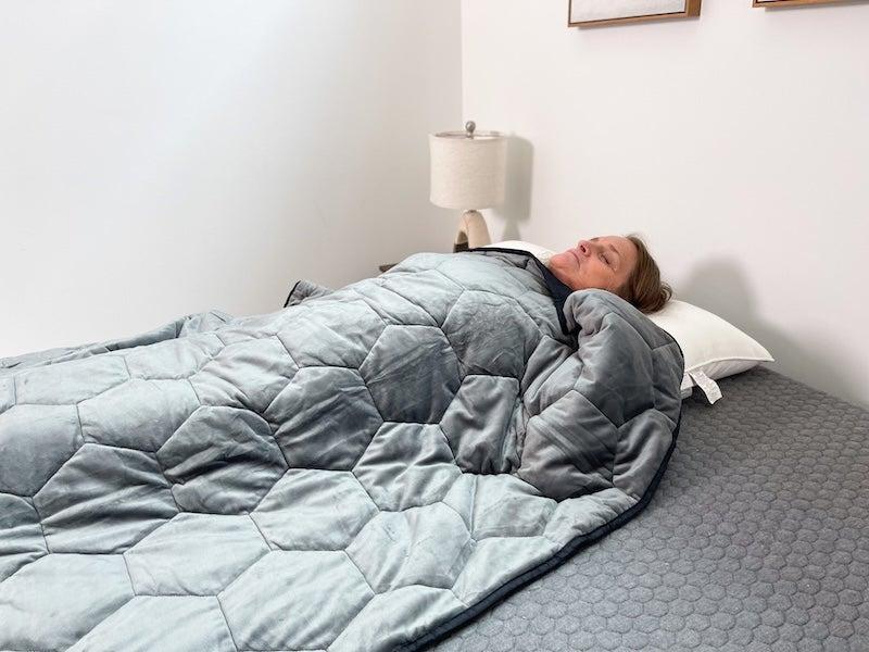 A woman lies underneath the Layla Weighted Blanket