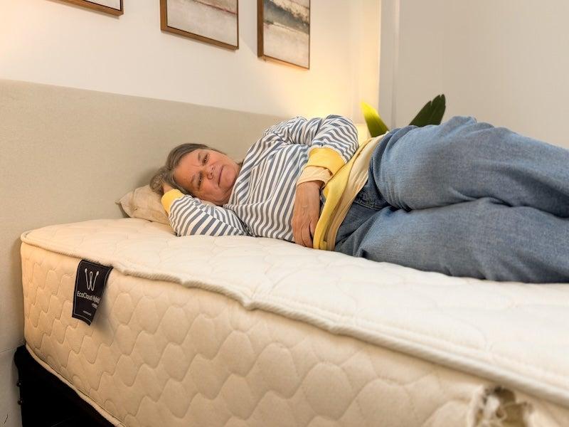 A woman lies on her side on the WinkBed EcoCloud
