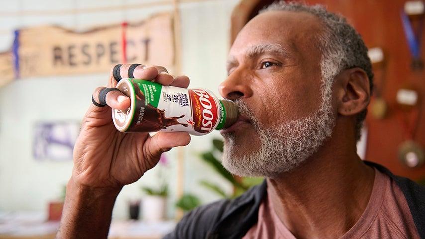 Man drinking BOOST nutrition beverage.