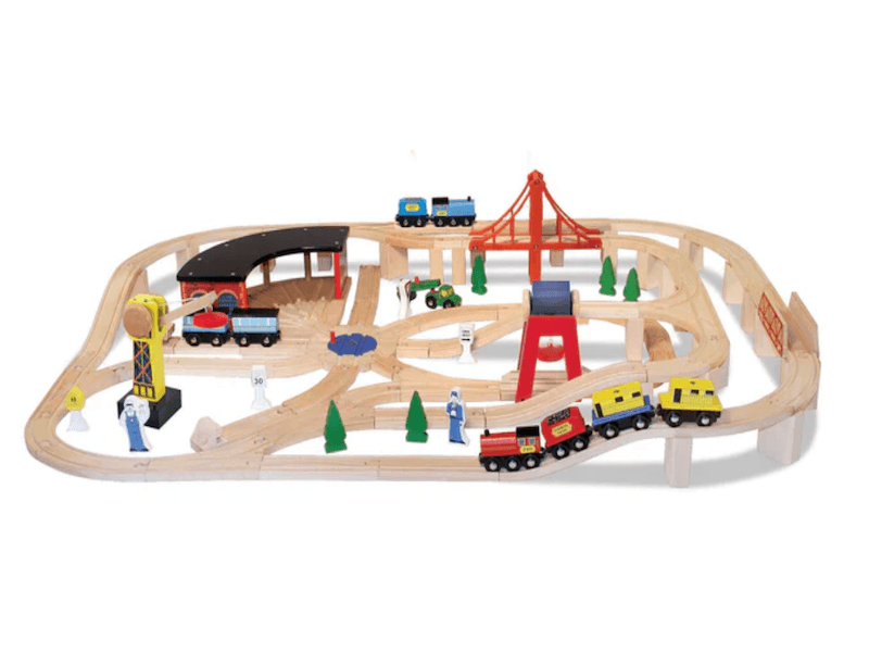 Wooden train set with several train cars, a bridge, and a train station