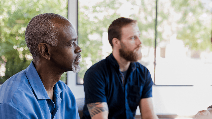 two men listening during a group counseling session