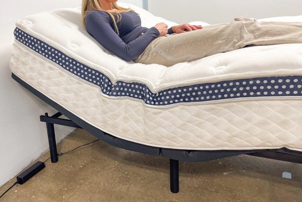A woman lying on the WinkBed Luxury Firm mattress on an adjustable base