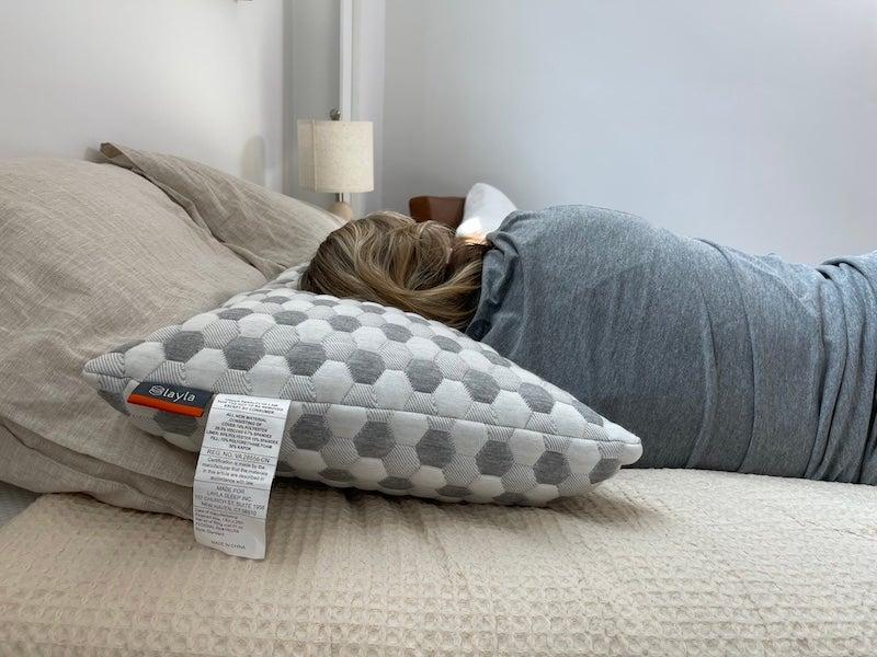 A woman lies on her side on the Layla Kapok pillow