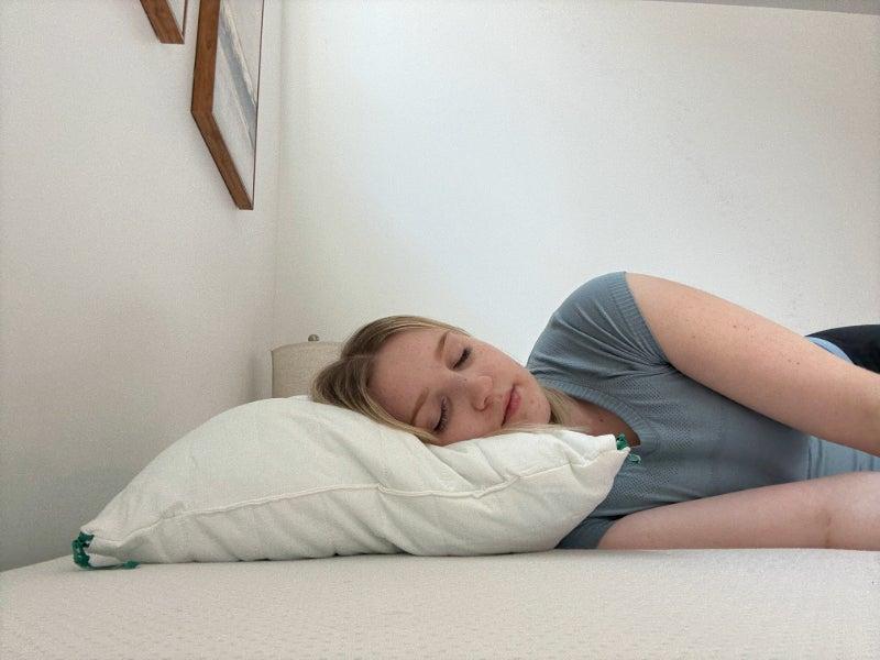 A woman sleeps on her side on the Brooklinen Marlow pillow.