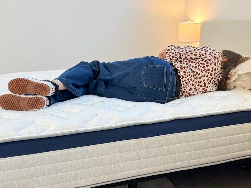 A woman lies on her side on the Helix Midnight hybrid mattress