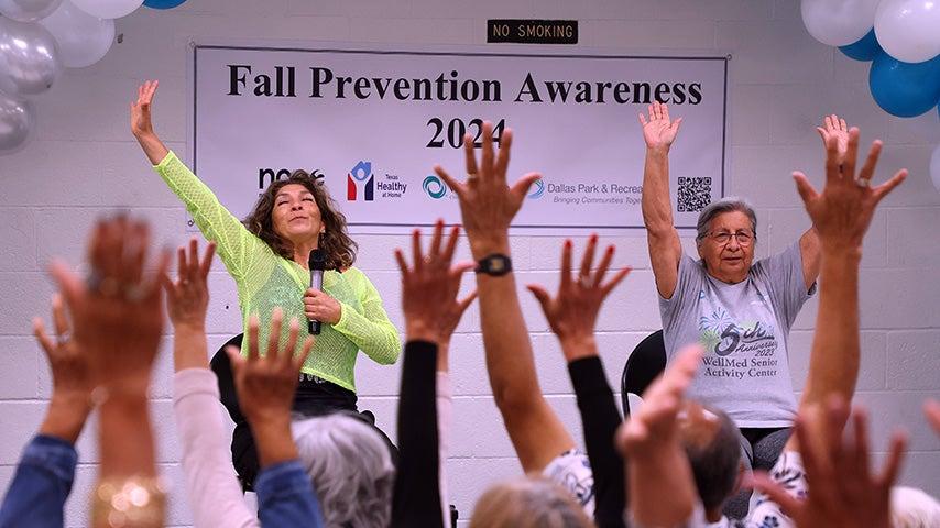 People in a group raise their hands.