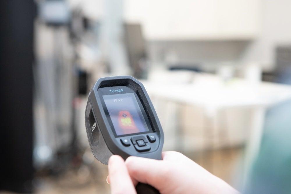 hand holding heat temperature measuring gun