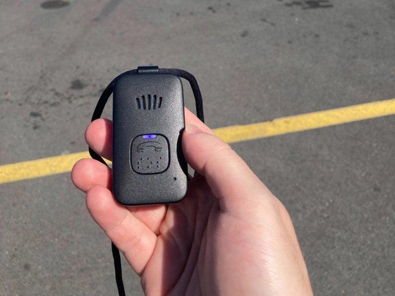 Medical Alert Mobile system in a person’s hand in a parking lot