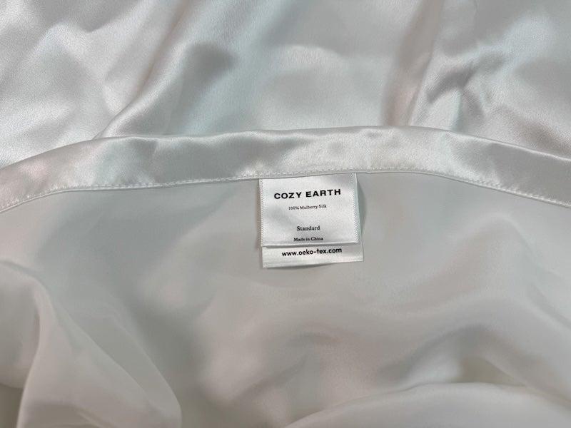 A white, silk Cozy Earth pillowcase opened up to show the label