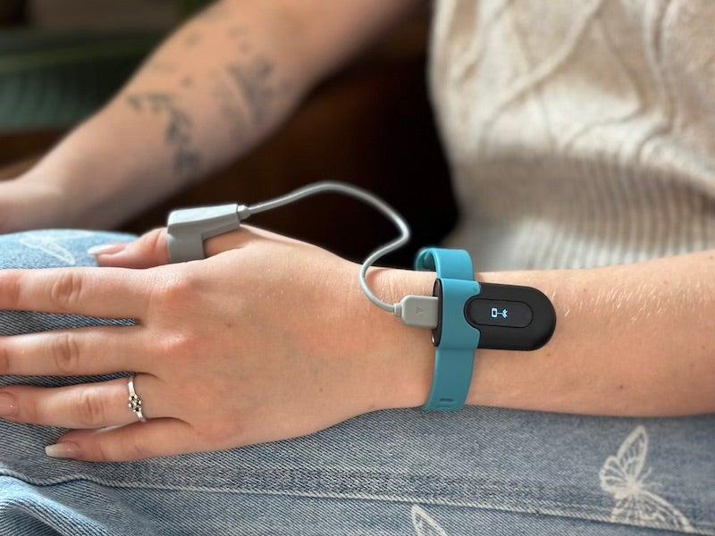 A woman wears the Wellue SleepU pulse oximeter
