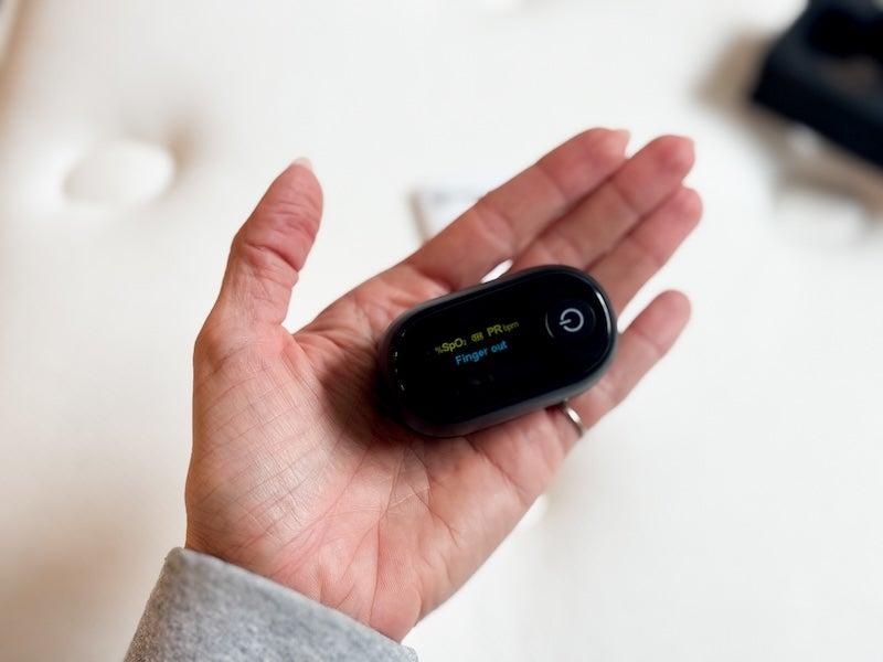 A woman holds the Oxiline 9S Pro in her hand