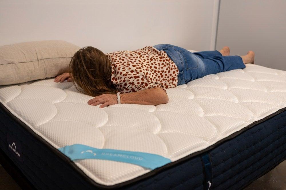 Woman lies on her stomach on the DreamCloud Premier Memory Foam mattress