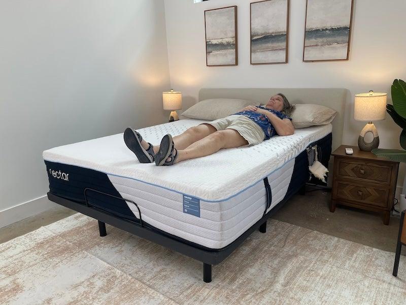 A woman lies on her back on the Nectar Classic Hybrid mattress