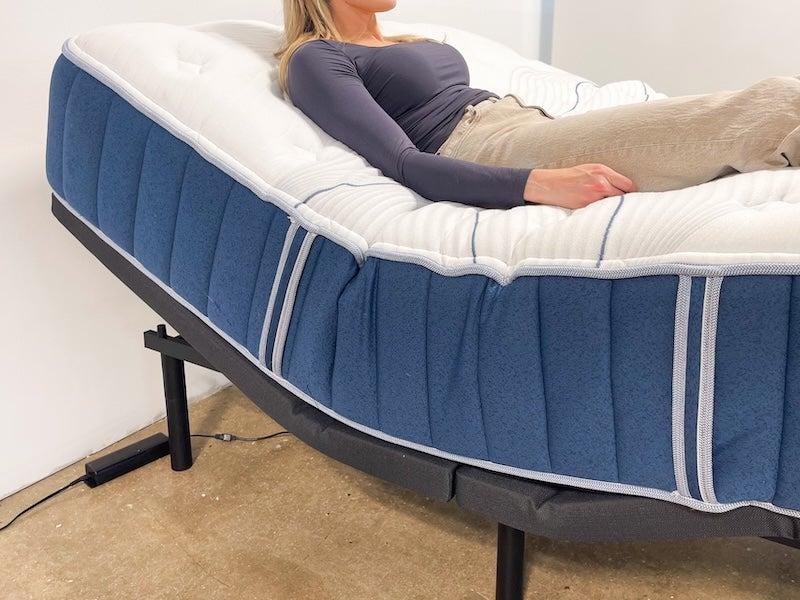 A woman lies on the Bear Elite Hybrid mattress in an adjustable frame