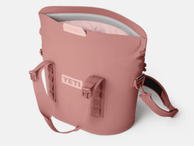 YETI brand soft cooler tote in sandstone pink, open to show interior and straps.