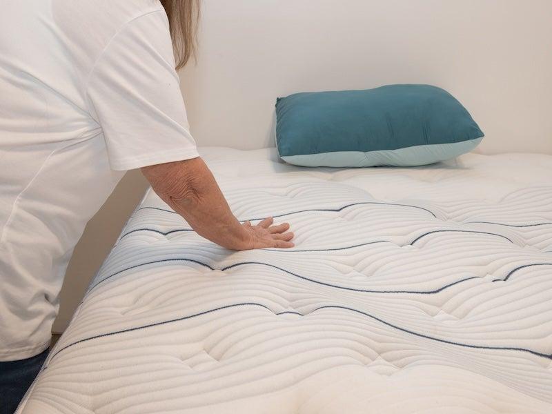 A woman pressing on the Bear Elite Hybrid mattress cover
