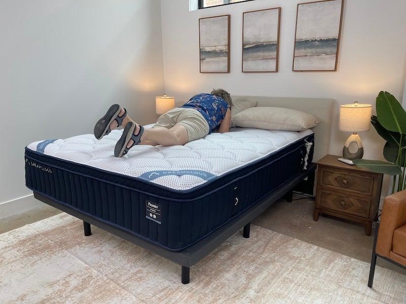 A woman rolling over on the DreamCloud Premier Hybrid Mattress