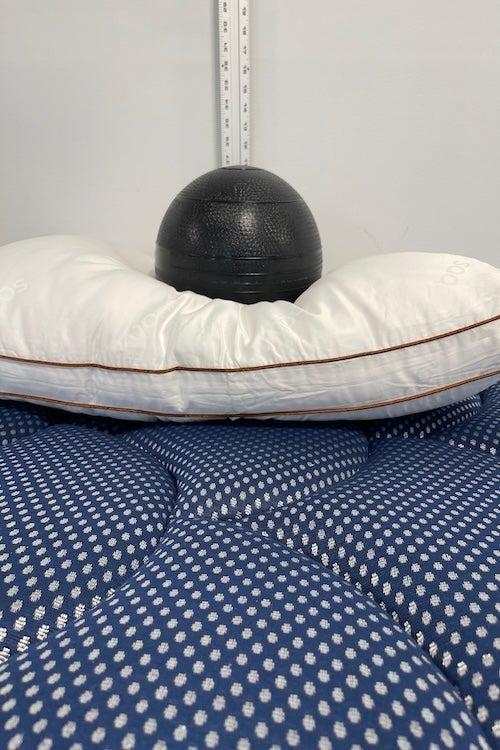 A medicine ball rests on top of the Saatva Latex pillow.